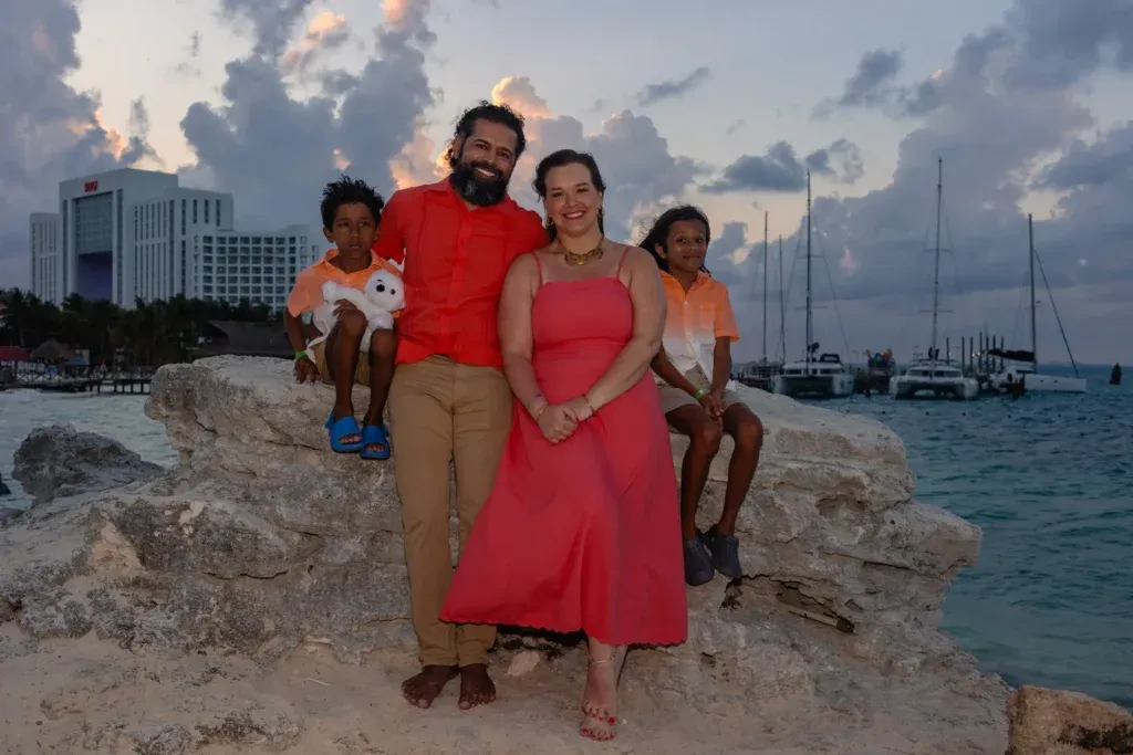 Family with young children posing during a sunset beach photography session at Playa Tortugas in Cancun.