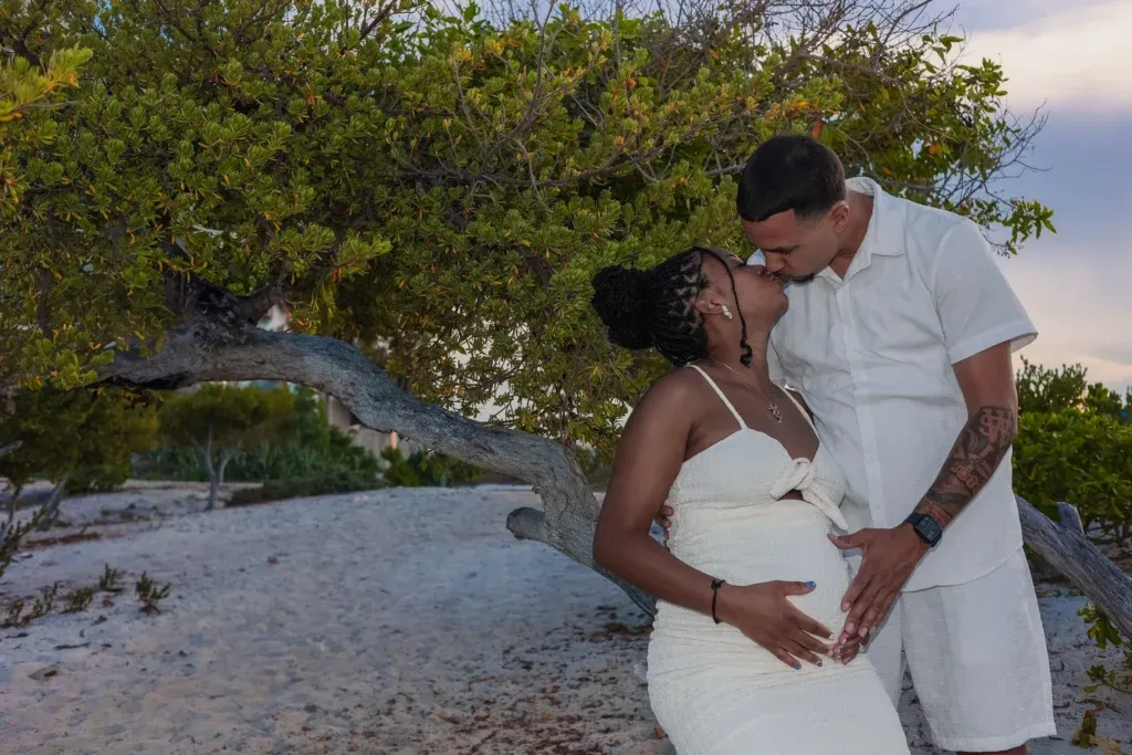 Cancun maternity photographer capturing a maternity session at Playa Delfines in Cancun with a pregnant couple and ultrasound at sunset.