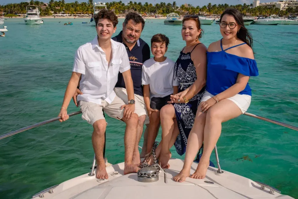 Cancun family photography session capturing a joyful 50th birthday celebration on a private yacht in the Caribbean Sea.