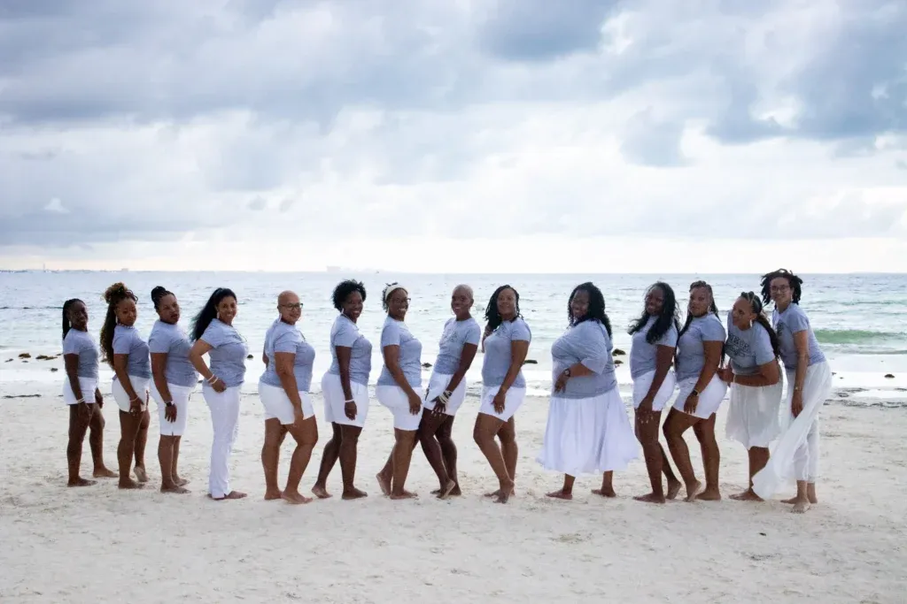 Group of sorority friends posing in white dresses during a photoshoot with a professional photographer in Cancun near Langosta Beach.